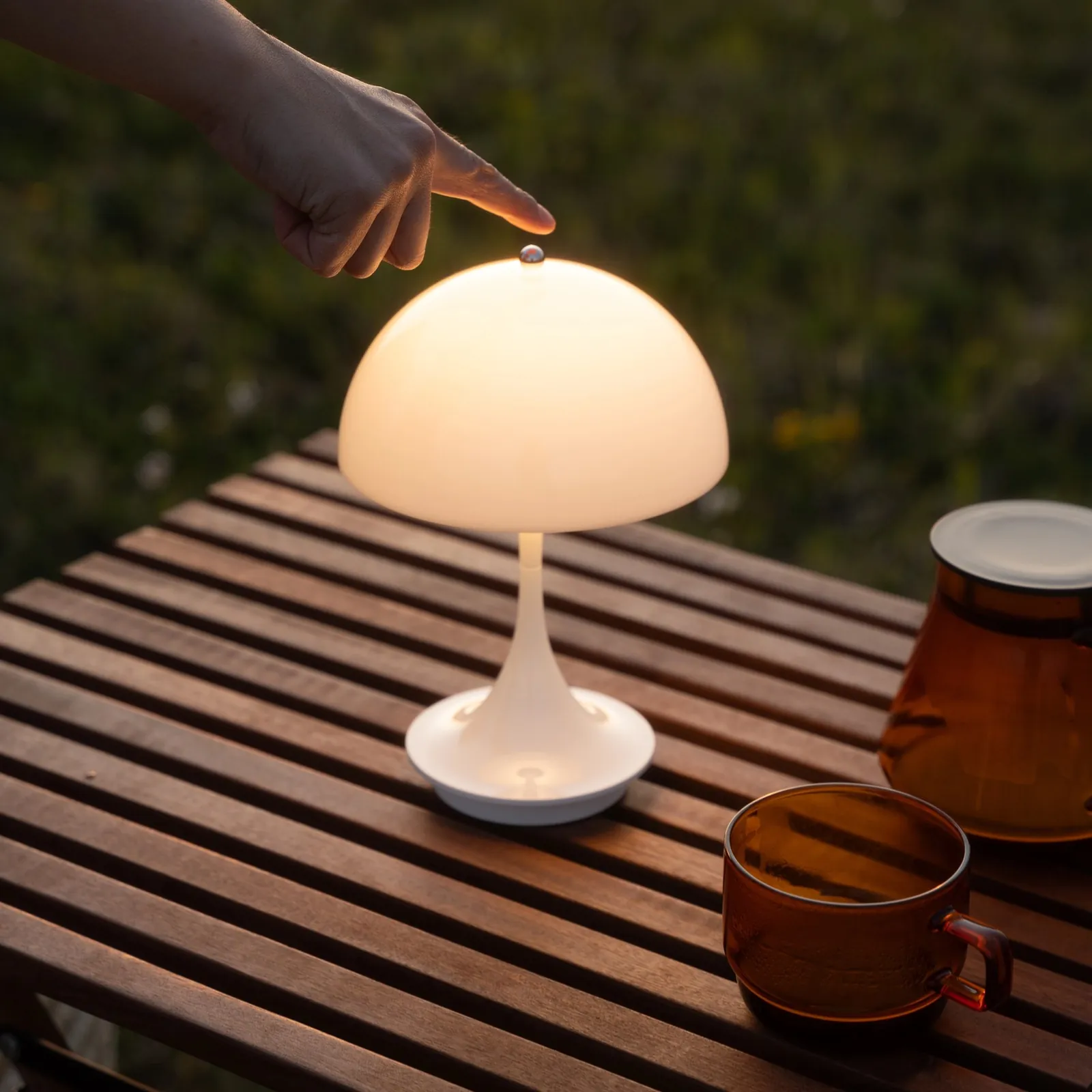 Geste : un doigt sur le haut de la lampe allumée (inspiration Louis Poulsen)