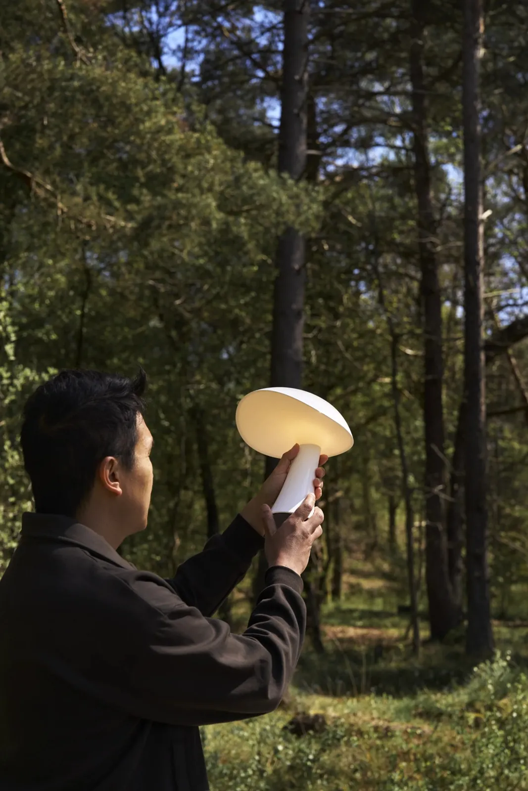 De profil, la lampe à la main (inspiration Louis Poulsen)