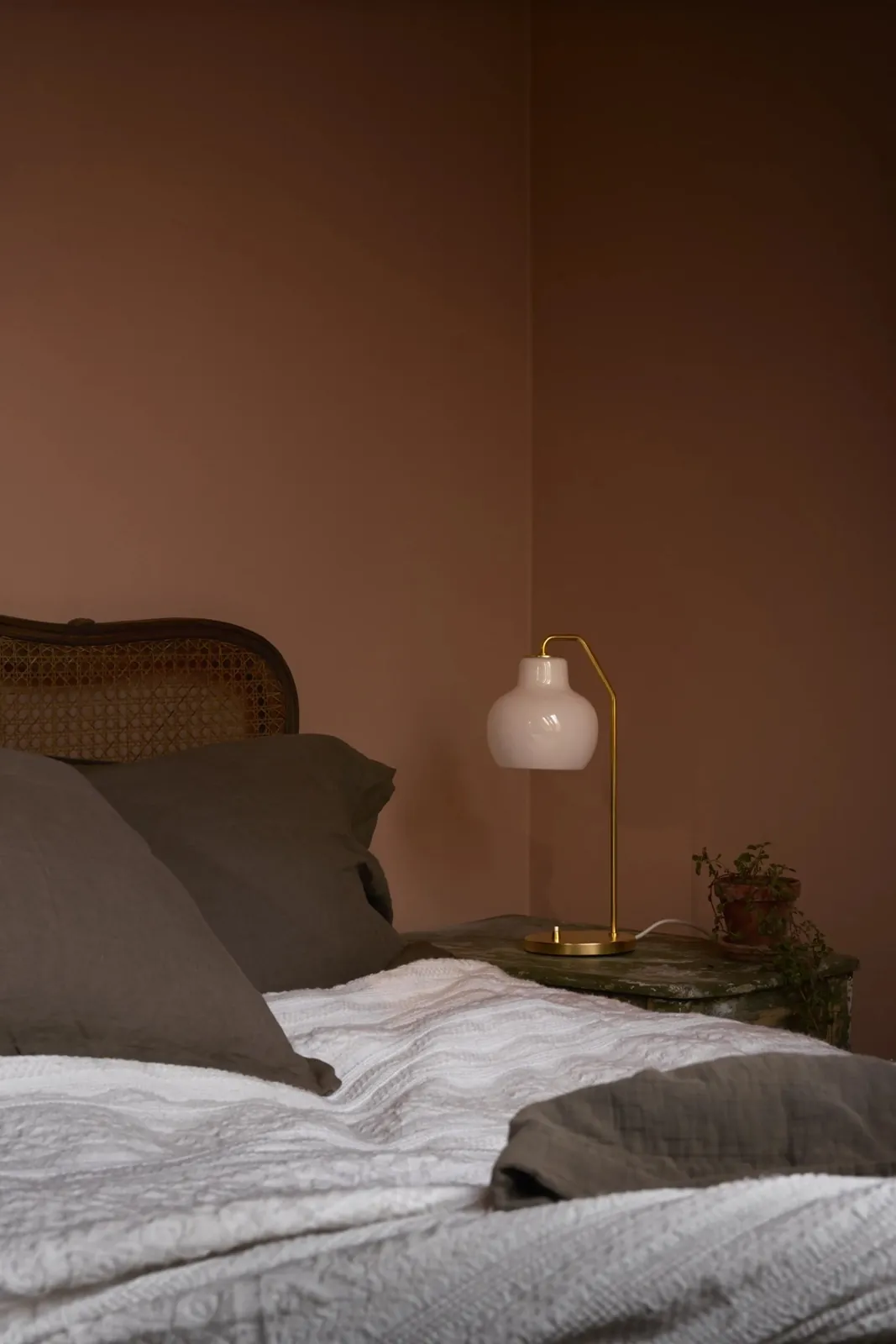 Soir : chambre terracotta, la lampe éclaire la scène (inspiration Louis Poulsen)