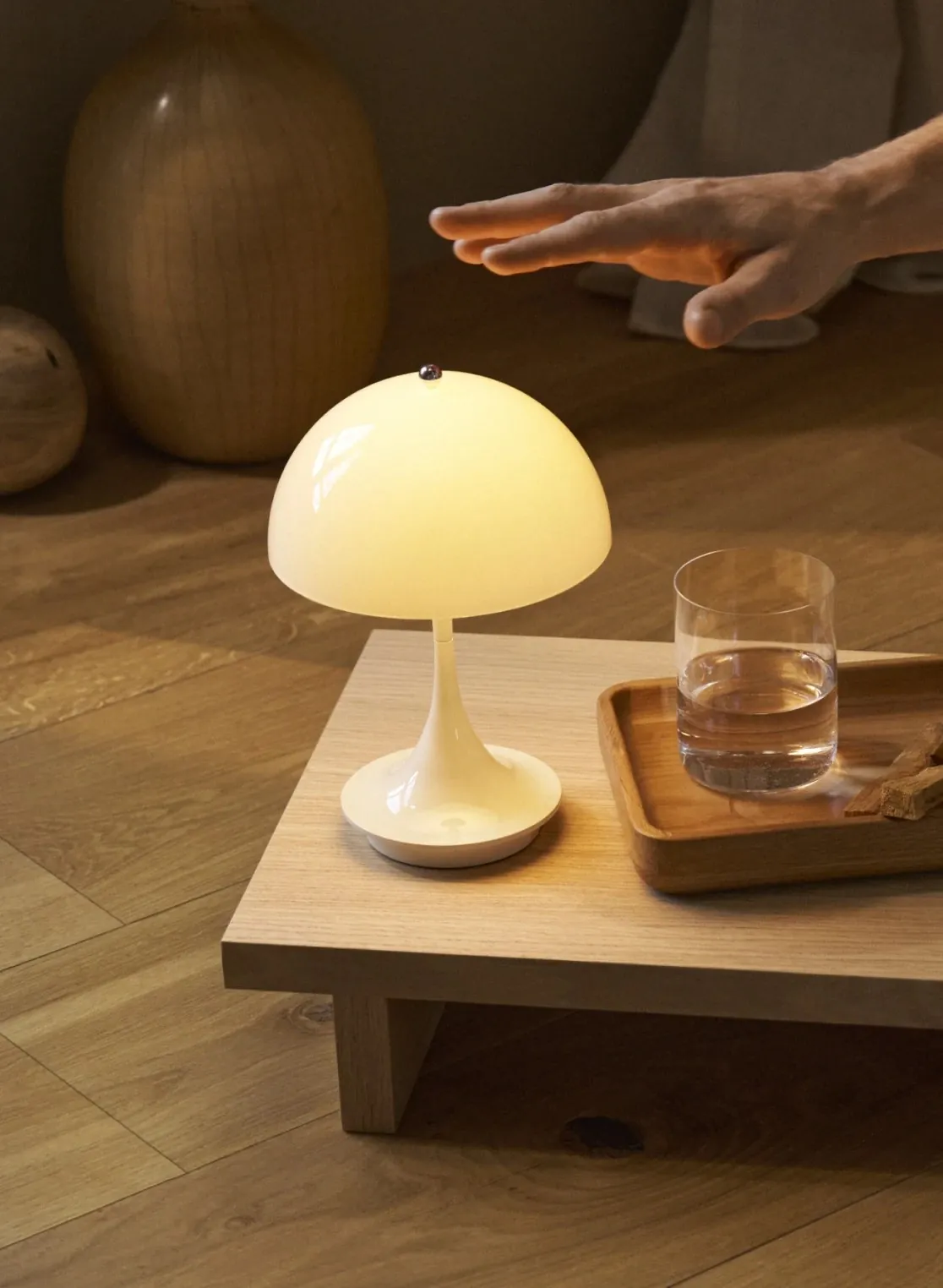 Une main au-dessus de la lampe (inspiration Louis Poulsen)
