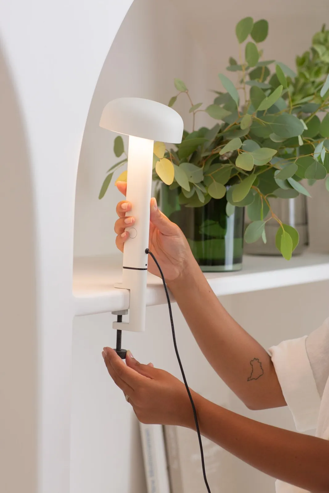 Une main fixe la lampe (inspiration TIPTOE)