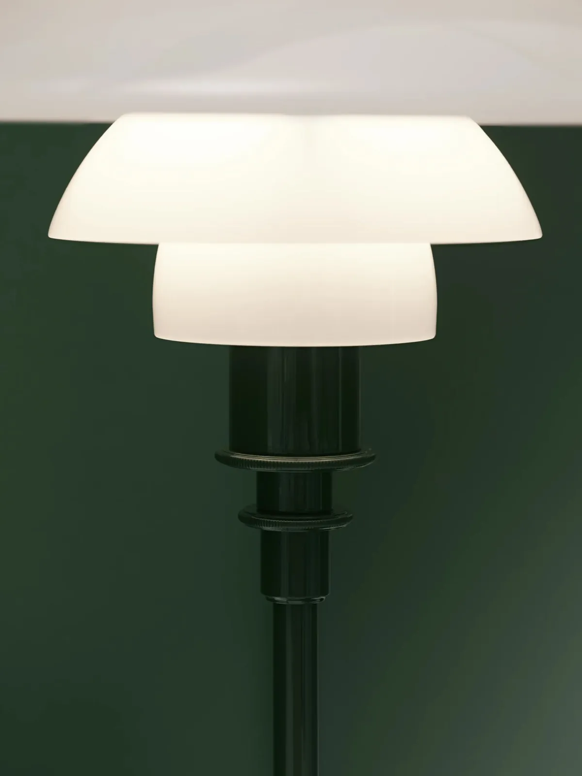 Lampe allumée sur un fond vert profond (inspiration Louis Poulsen)